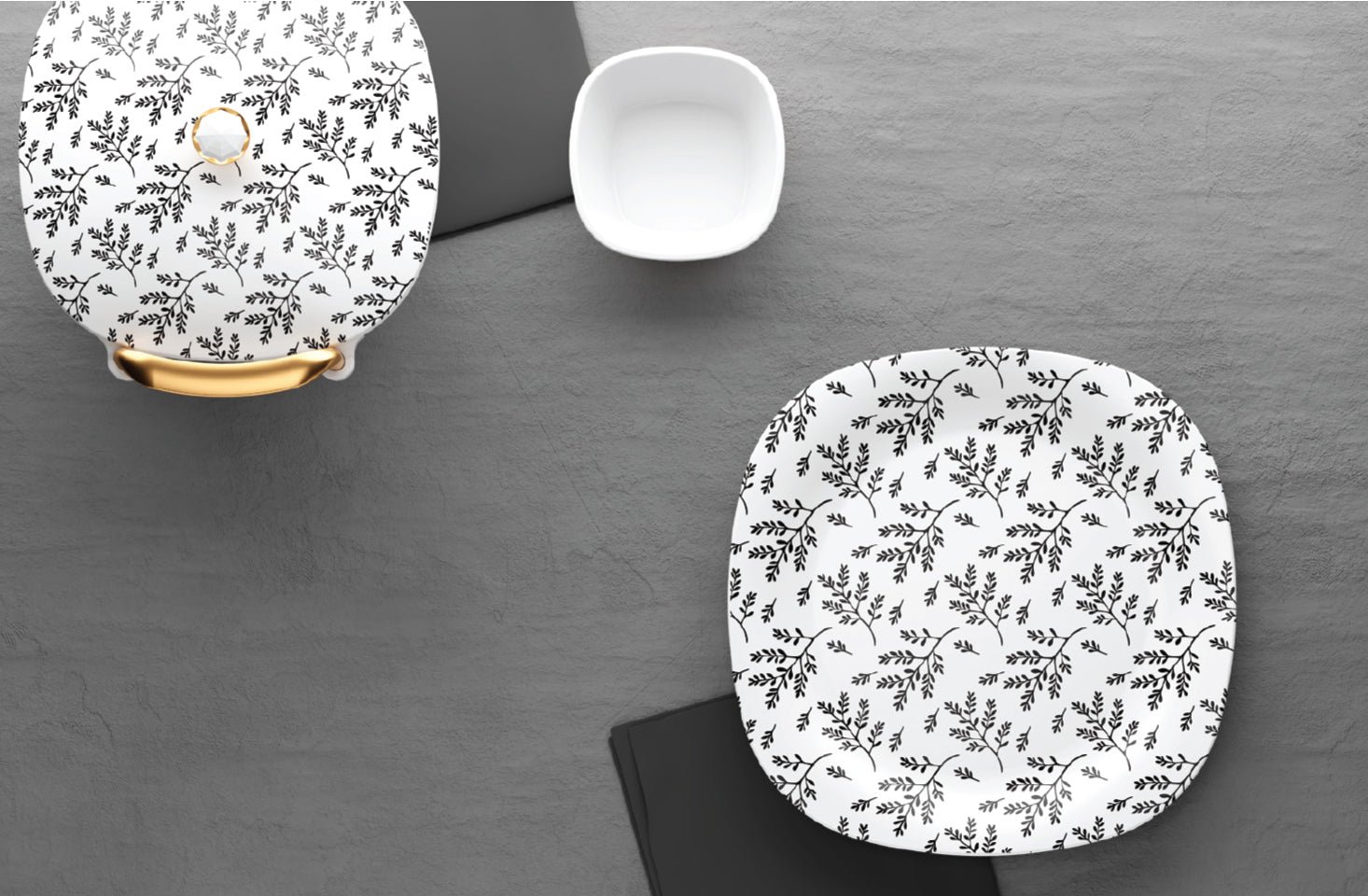 Black leaf dinnerware styled on a grey background